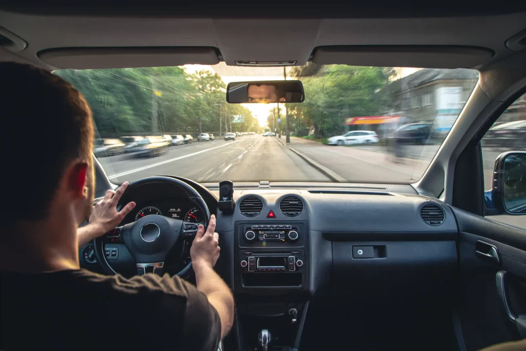 interior view of a car being driven showcasing the dashboard and steering wheel.