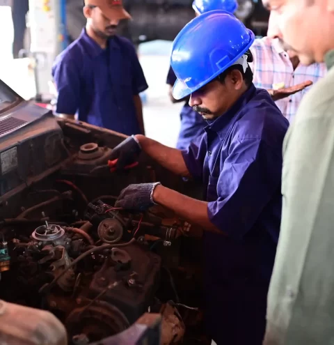 A Mechanic examining an engine to determine what is reusable.